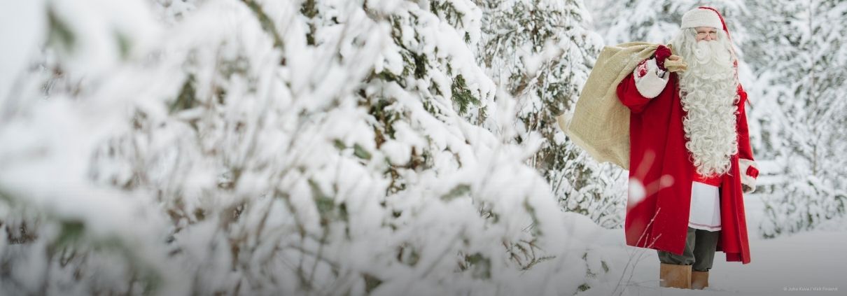 Santa Claus standing in a snowy landscape at Santa Claus Village